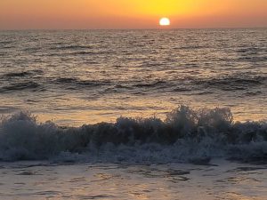 Waves rolling in on the beach at sunset