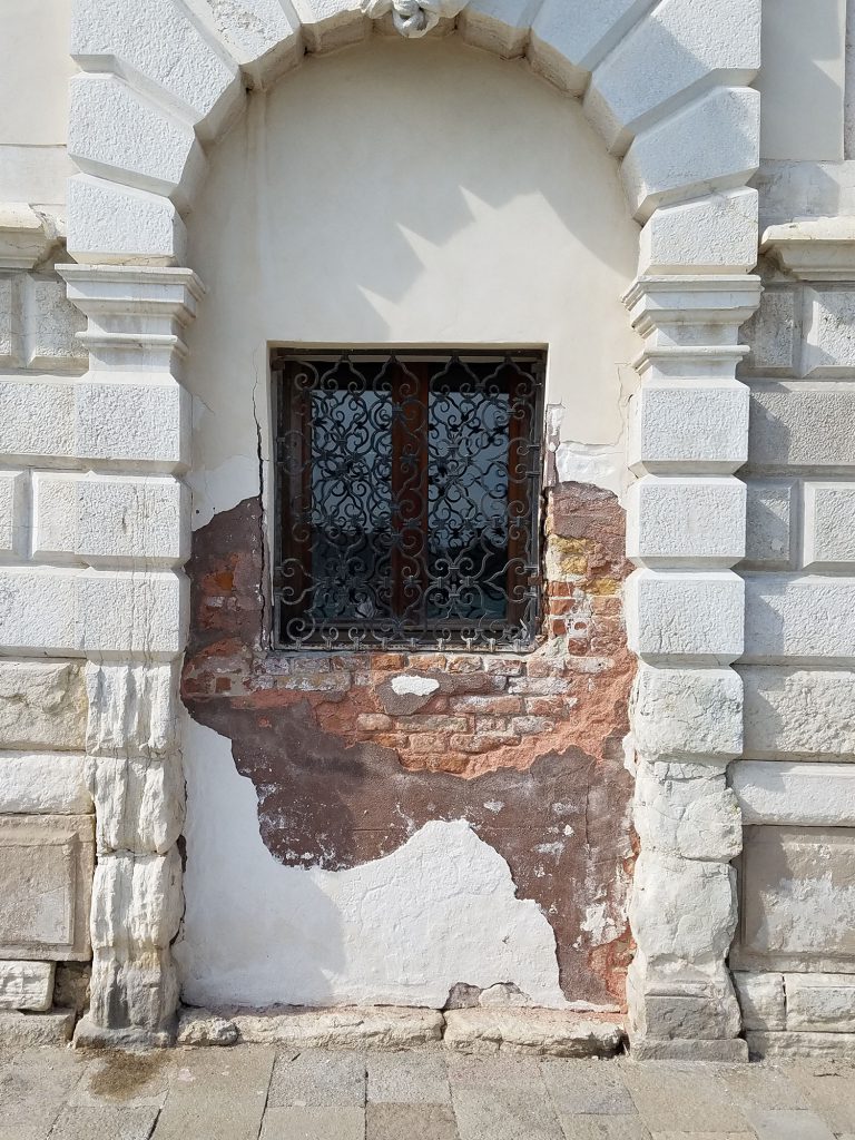 white brick arch with rod iron window