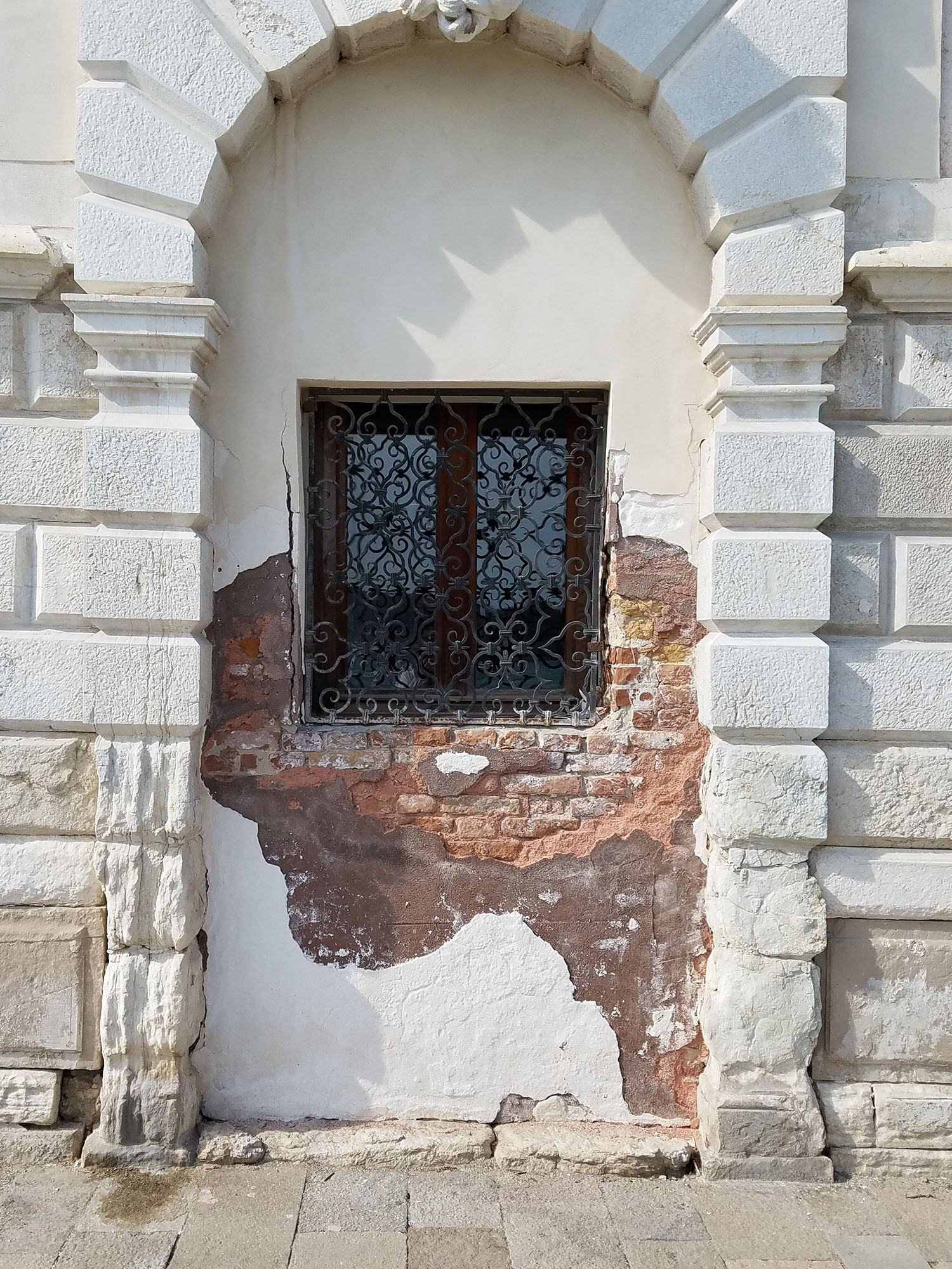 white brick arch with rod iron window